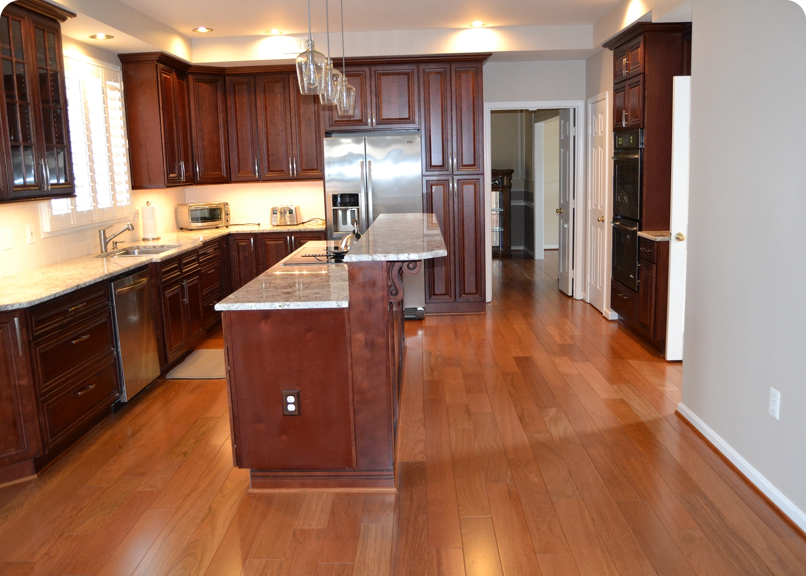 Spacious kitchen with wooden cabinets and flooring.