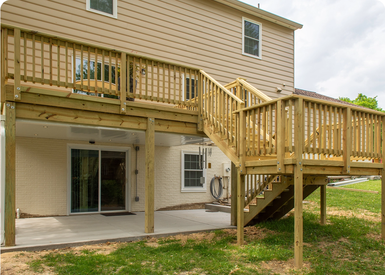 Wooden deck with stairs behind house.