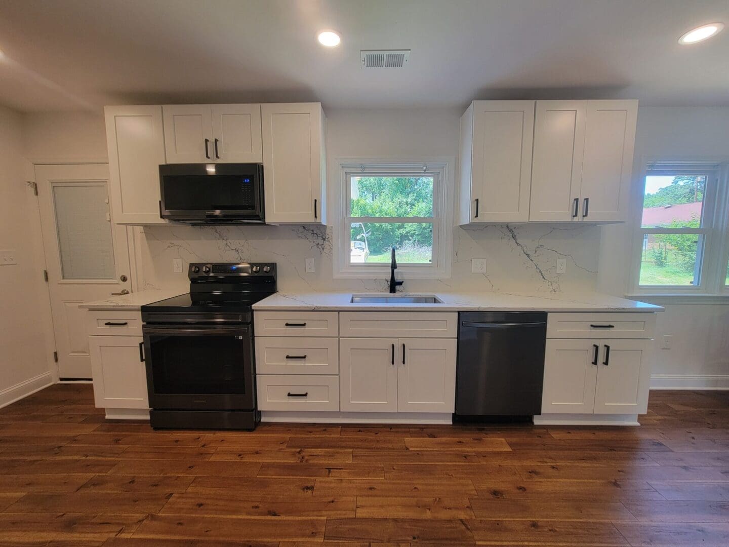 Modern kitchen with white cabinets and appliances.