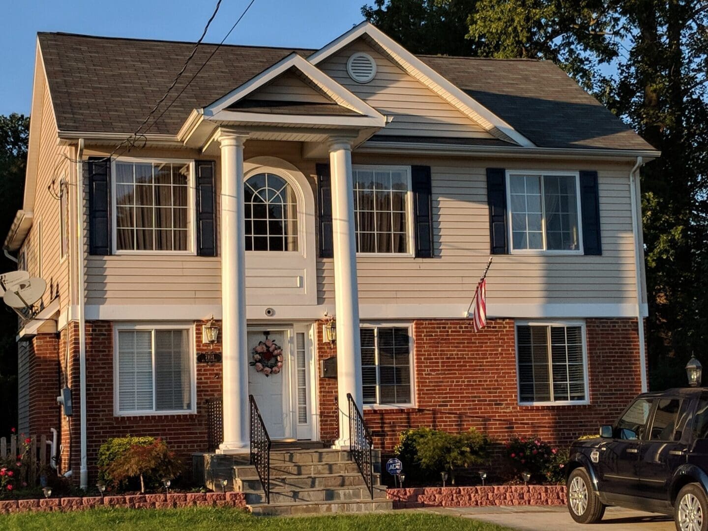 Two-story house with columns and flag.